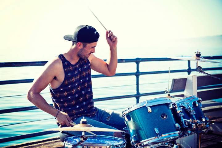 man playing drums near bay