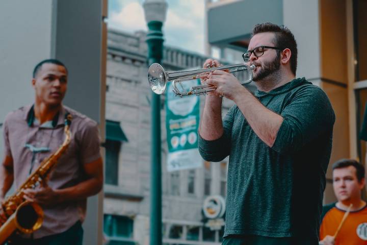 man playing trumpet on street